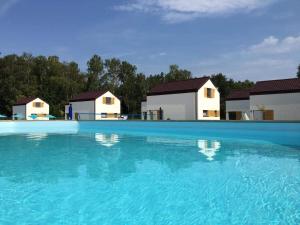 a large swimming pool with houses in the background at Domki Lawendowe in Łeba