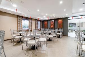 - une salle à manger avec des tables, des chaises et des fenêtres dans l'établissement Jinjiang Inn - Ortigas, à Manille