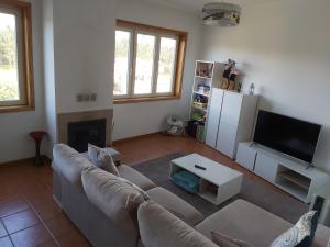 a living room with a couch and a fireplace at Ulfilanis Vila - charme e conforto a 10 km de Santa Maria da Feira in Fiães