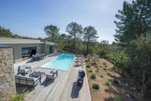 eine Luftansicht auf einen Pool mit Stühlen und ein Haus in der Unterkunft Maison Del Onda in Lecci