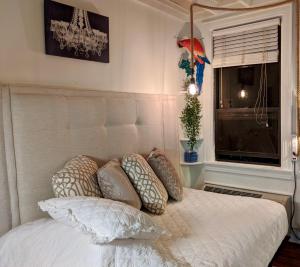 a bedroom with a bed with pillows and a window at Palm Beach Hotel Petite Retreat 2 blocks to beach!! Historic Landmark in Palm Beach +11 photos