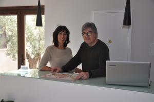 Ein Mann und eine Frau sitzen an einem Tisch mit einem Laptop in der Unterkunft Hotel La Vera Cruz in Caravaca de la Cruz