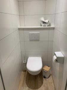 La salle de bains est pourvue de toilettes blanches et d'un mur carrelé blanc. dans l'établissement Chambres d'hôtes Logis Charrier Le Petit Bignon, aux Épesses