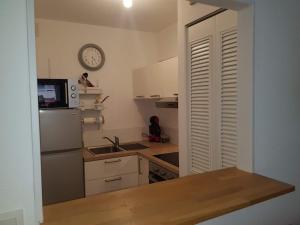 una cucina con un lavandino e un orologio a parete di Fréjus plage a Fréjus Altre 13 foto