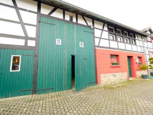 een gebouw met een groene deur en een rood gebouw bij Lutterbach in Monschau