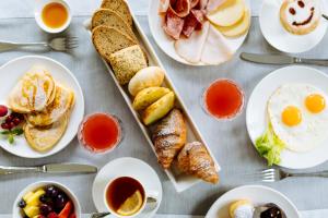 a table with plates of breakfast foods and drinks at Hotel St.Mauritius in Forte dei Marmi