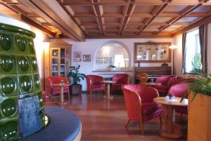 ein Wartezimmer mit roten Stühlen und einem Tisch in der Unterkunft Hotel Alpino in Varena