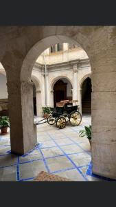 ein Torbogen mit einer Pferdekutsche in einem Gebäude in der Unterkunft Hotel Ordóñez Sandoval in Úbeda