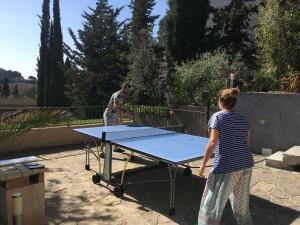 a man and a woman playing a ping pong table at BY Cassis chambre privée dans maison familiale in Cassis