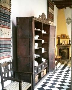 a large wooden cabinet with dishes inside of a room at Hotel Ordóñez Sandoval in Úbeda