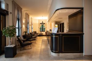 a salon with a bar with chairs and a mirror at Hotel Kasteel Solhof in Aartselaar