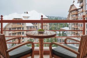 a table and two chairs on a balcony with a view at Four Seasons Resort Whistler in Whistler