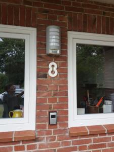 uma casa de tijolos com duas janelas e uma luz sobre ela em Ferienhaus Richard em Husum