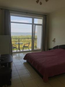 a bedroom with a bed and a view of a balcony at Гостиница «Флинт» in Zatoka