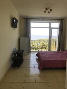 a bedroom with a bed and a balcony with a view at Гостиница «Флинт» in Zatoka
