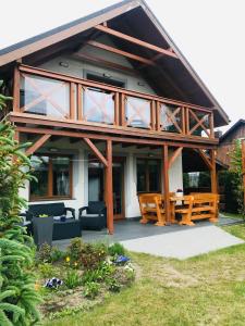 a home with a large wooden house with a patio at Chata Zaciszne Zastań in Międzywodzie