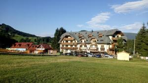 a large building with cars parked in a parking lot at Donovaly AD Kamzík - apartmán 47 in Donovaly