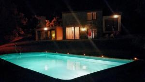 a swimming pool in front of a house at night at Casa do Lavadouro in Paços de Gaiolo