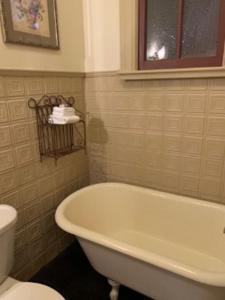 a bathroom with a white tub and a toilet at Hotel St Nicholas in Cripple Creek