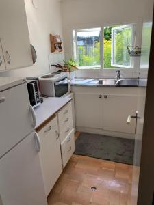 a kitchen with white cabinets and a sink and a window at Private house Parking Garden Sea Nature in Malmö