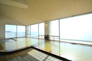 a pool of water in a room with windows at Ibusuki Seaside Hotel in Ibusuki