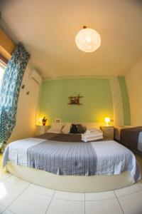 カスティリオーネ・デル・ラーゴにあるAffittacamere Le Petit Palaisの緑の壁にベッドが備わるベッドルーム1室