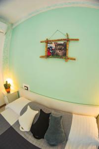カスティリオーネ・デル・ラーゴにあるAffittacamere Le Petit Palaisのベッドルーム1室(壁に猫の絵が描かれたベッド1台付)