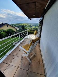 uma cadeira branca numa varanda com vista em Die grüne Oase am RheinSteig 2 ZKBuWC em Neuwied