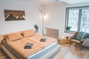 una camera da letto con un letto e una sedia di FURU Hostel & Café a Bøstad