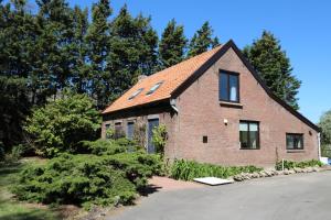 a brick house with a red roof at Hof Zuidvliet in Wolphaartsdijk