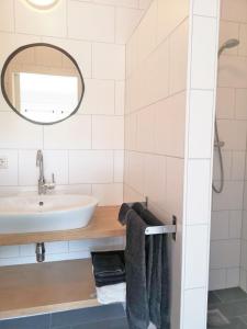 a bathroom with a sink and a mirror and towels at ZuidoostWestkapelle in Westkapelle