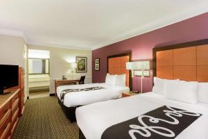 um quarto de hotel com duas camas e uma televisão de ecrã plano em La Quinta Inn by Wyndham and Conference Center San Angelo em San Angelo