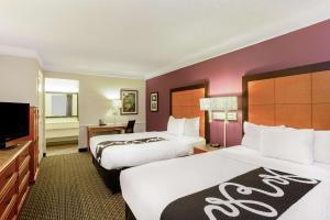 a hotel room with two beds and a flat screen tv at La Quinta Inn by Wyndham and Conference Center San Angelo in San Angelo