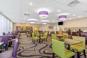 uma sala de jantar com mesas e cadeiras e roxo e verde em La Quinta Inn by Wyndham and Conference Center San Angelo em San Angelo