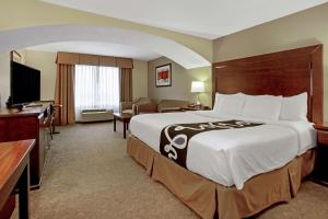 a hotel room with a large bed and a television at La Quinta by Wyndham Bismarck in Bismarck