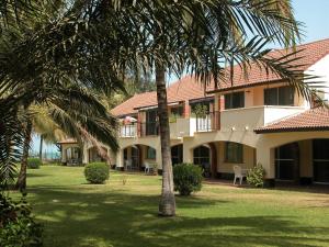 a building with palm trees in front of it at Kololi Beach Resort in Kololi