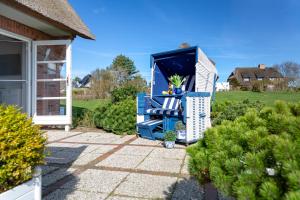 een paar blauwe stoelen op een patio bij Watthüs in Morsum