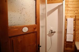 a bathroom with a shower and a wooden door at Gîte de Planchouet in Nendaz