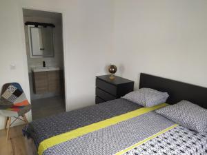 a bedroom with a bed and a bathroom with a sink at Agréable T2 au calme proche gare in Perpignan