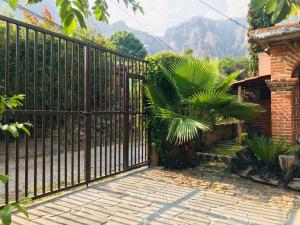 une clôture noire avec un palmier devant une maison dans l'établissement Posada Teopanco, à Tepoztlán