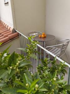 einen Tisch und Stühle auf einem Balkon mit Orangen darauf in der Unterkunft Agréable T2 au calme proche gare in Perpignan