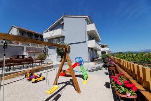 una casa con un parque infantil delante de ella en L&R Apartmani en Vrh