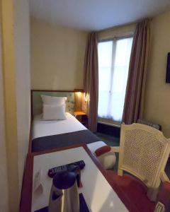 a hotel room with a bed and a window at France Louvre in Paris