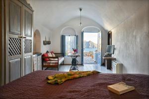 a bedroom with a bed and a living room at Lava Oia's in Oia