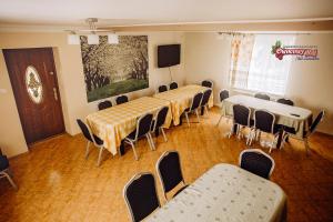 Sala de conferencias con mesas, sillas y TV en Owocowy Raj Nad Zalewem, en Modła Królewska