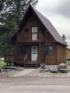 ein großes Holzhaus mit einer Veranda und einem Balkon in der Unterkunft Chalet in Hill City