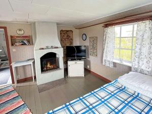 een slaapkamer met een open haard, een bed en een televisie bij 4 person holiday home in L TTORP in Löttorp