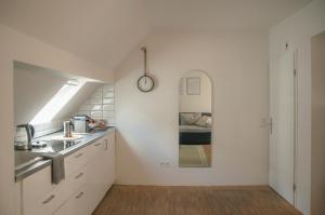 een keuken met een wastafel en een klok aan de muur bij Altstadt Apartment Centralissimo in Düsseldorf