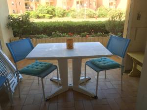 ル・バルカレスにあるPalm Beachの白いテーブル(青い椅子2脚、カップ付)