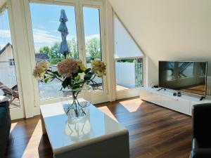 a living room with a vase of flowers on a table at Ferien-Apartment Haubentaucher - mit priv Strandzugang in Friedrichshafen